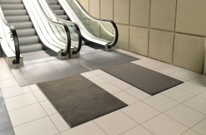 Dark grey mats by escalator